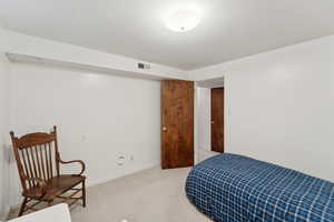 Bedroom featuring light carpet and baseboards