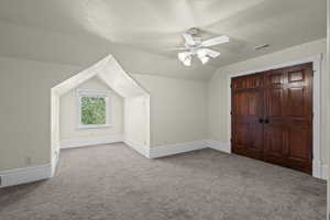 Additional living space with carpet floors, ceiling fan, lofted ceiling, and baseboards