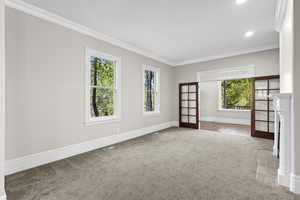 Empty room with carpet flooring, crown molding, plenty of natural light, baseboards, and recessed lighting