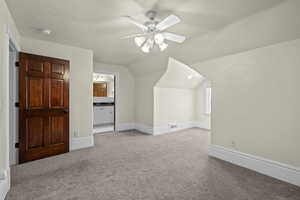 Bonus room featuring carpet floors, a ceiling fan, vaulted ceiling, and baseboards