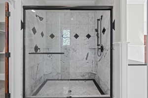 Bathroom featuring ornamental molding and a shower stall