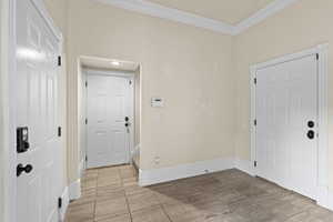 Entrance foyer with ornamental molding and baseboards