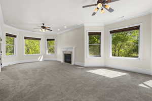 Unfurnished living room with a ceiling fan, plenty of natural light, carpet floors, ornamental molding, and recessed lighting