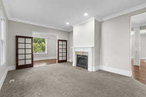 Unfurnished living room featuring a tile fireplace, ornamental molding, baseboards, carpet flooring, and recessed lighting