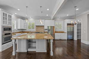 Kitchen with open shelves, built in appliances, healthy amount of natural light, a sink, and crown molding