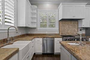 Kitchen featuring a sink, ornamental molding, white cabinetry, dark wood-style floors, and dishwasher
