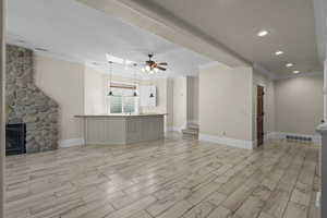 Unfurnished living room with crown molding, light wood-type flooring, baseboards, ceiling fan, and recessed lighting