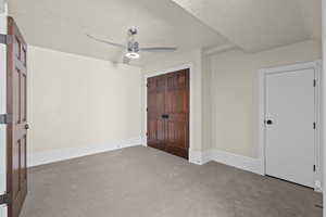 Unfurnished bedroom with carpet floors, baseboards, and a ceiling fan