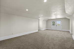 Bonus room with light colored carpet, recessed lighting, baseboards, a textured ceiling, and vaulted ceiling