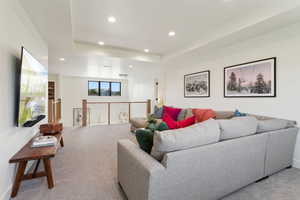Living room with recessed lighting, light colored carpet, and baseboards