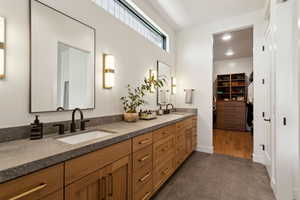 Bathroom with double vanity, a walk in closet, tile patterned flooring, and baseboards