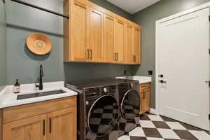 Washroom with cabinet space, washer and dryer, and tile patterned floors