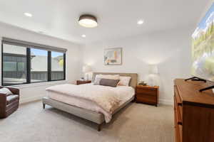 Bedroom with light carpet, baseboards, and recessed lighting