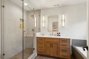 Full bath with a shower stall, vanity, tile patterned floors, and tiled tub