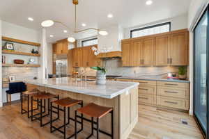Kitchen with built in fridge, a sink, backsplash, plenty of natural light, and recessed lighting