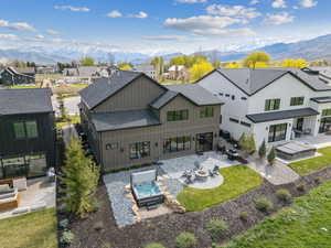 Rear view of property with roof with shingles, a patio, a mountain view, and board and batten siding