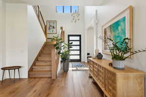 Entryway featuring stairway, hardwood / wood-style flooring, and baseboards