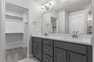 Full bathroom with a walk in closet and double vanity