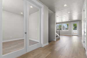 Hall with recessed lighting, stairs, light wood-style floors, and a textured ceiling
