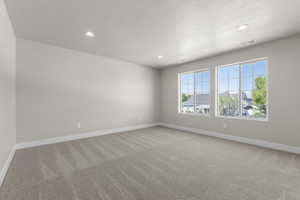 Spare room with light colored carpet, recessed lighting, and a textured ceiling
