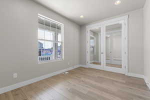 Spare room featuring french doors, light wood-style flooring, and recessed lighting