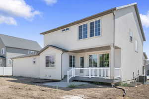 Rear view of house featuring stucco siding and a wooden deck