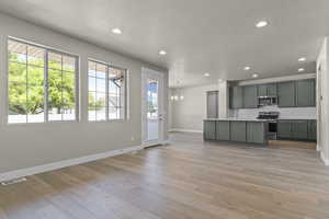 Kitchen featuring recessed lighting, pendant lighting, an island with sink, stainless steel appliances, and open floor plan