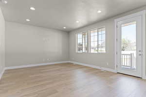 Empty room with recessed lighting, light wood finished floors, and a textured ceiling