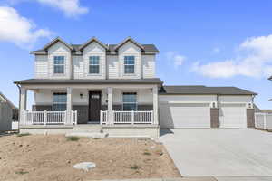 View of front of home with brick siding, a porch, driveway, and a garage