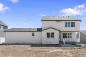 Back of house featuring roof with shingles, stucco siding, and a deck