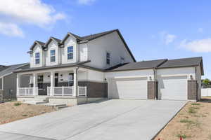 View of front of home featuring a porch, brick siding, driveway, an attached garage, and roof with shingles