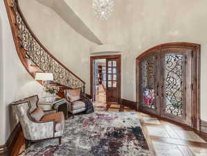 Entrance foyer , a towering ceiling, stairway, arched walkways, and french doors