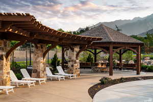 Community pool/ outdoor hangout area, fence, a mountain view, pergola, and a patio area