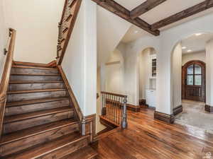 Second Stairway featuring arched walkways, beam ceiling, recessed lighting, and wood-type flooring