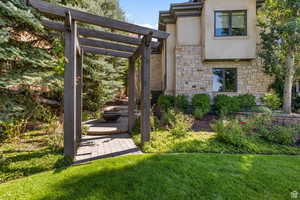 View of side of property with stone /stucco siding, and pergola