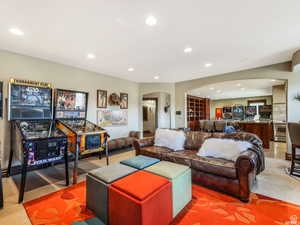 Living area with carpet flooring, arched walkways, and recessed lighting