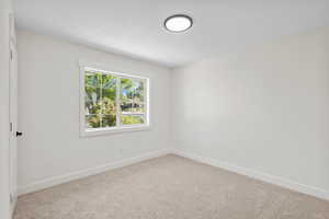 Empty room featuring baseboards and carpet floors