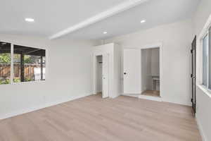 Unfurnished bedroom with light wood finished floors, beamed ceiling, recessed lighting, and baseboards