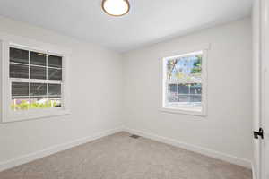 Carpeted empty room with baseboards