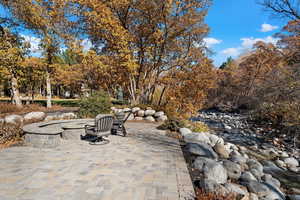 View of patio / terrace featuring a fire pit and view of scattered trees