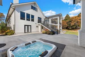 Rear view of house with french doors, stairway, a patio area, a chimney, and stucco siding