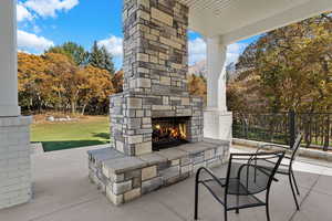View of patio / terrace with an outdoor stone fireplace and a mountain view
