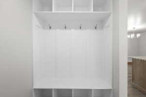 Mudroom with wood finished floors and a chandelier