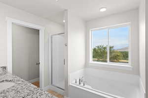Full bath featuring a bath, a shower stall, double vanity, and light tile patterned floors