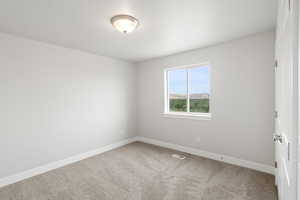 Unfurnished room with light carpet and a mountain view