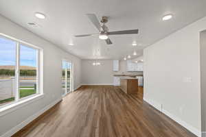 Unfurnished living room featuring a chandelier, dark wood-style floors, a ceiling fan, a textured ceiling, and recessed lighting