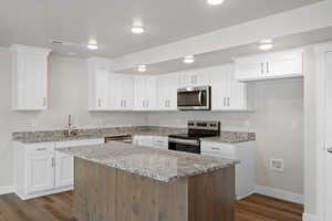 Kitchen featuring appliances with stainless steel finishes, a center island, white cabinets, and recessed lighting