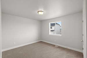 Spare room featuring carpet flooring and a textured ceiling