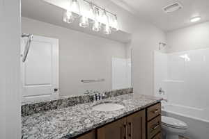 Bathroom with vanity,  shower combination, and a textured ceiling