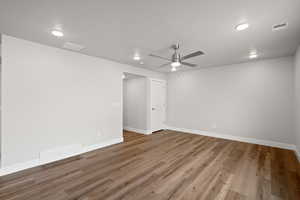 Empty room featuring light wood finished floors, a ceiling fan, and a textured ceiling